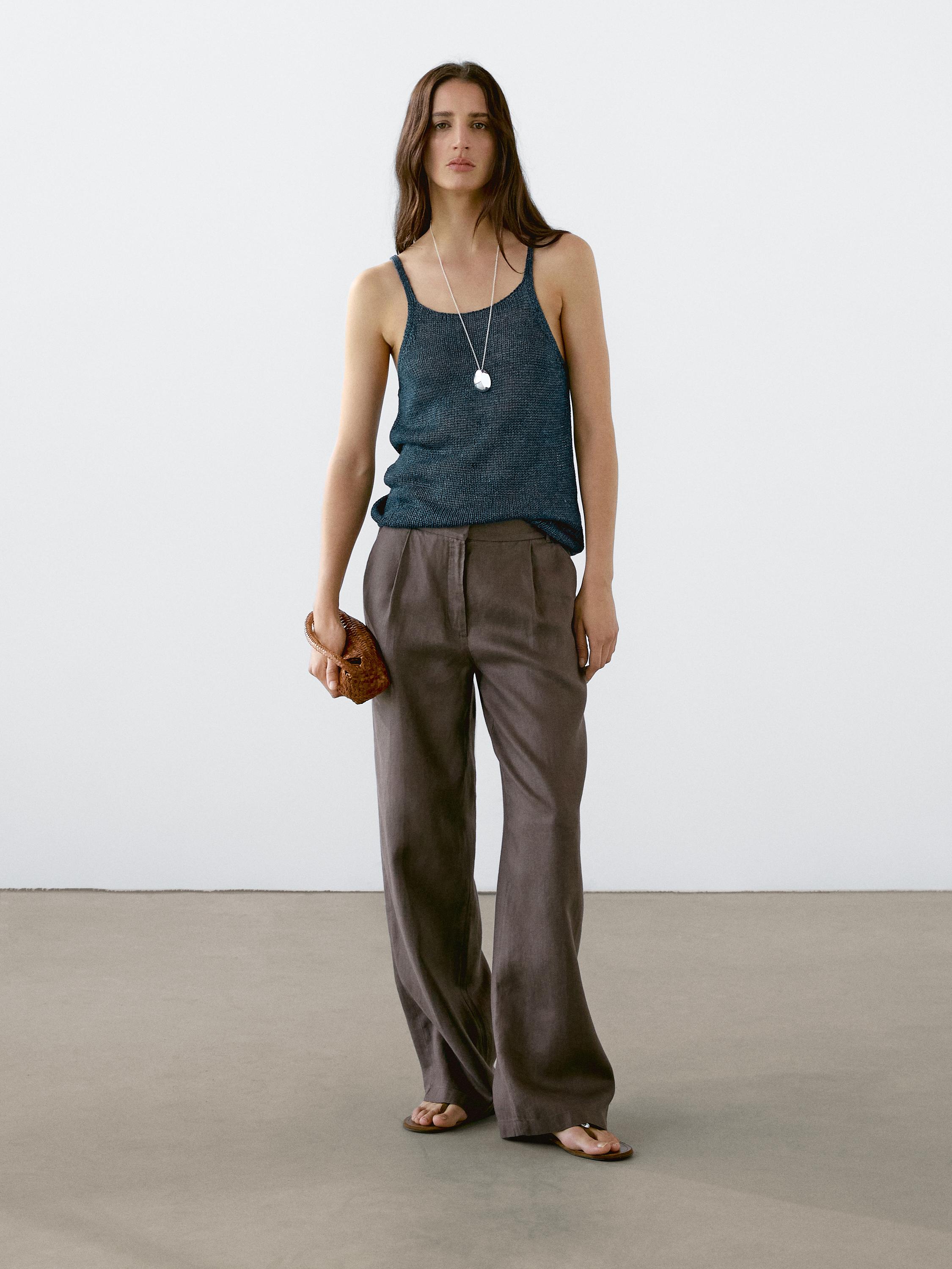 Conjunto de top de tirantes azul y pantalones marrones amplios.